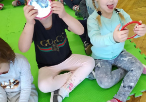 Dziewczynki ćwiczą buzię i język przy pomocy lusterka